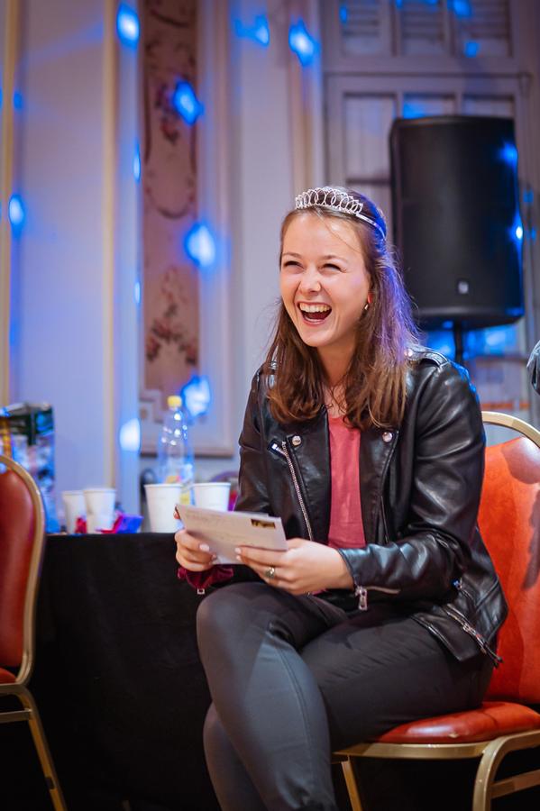 Une jeune femme rit en lisant une carte d'anniversaire
