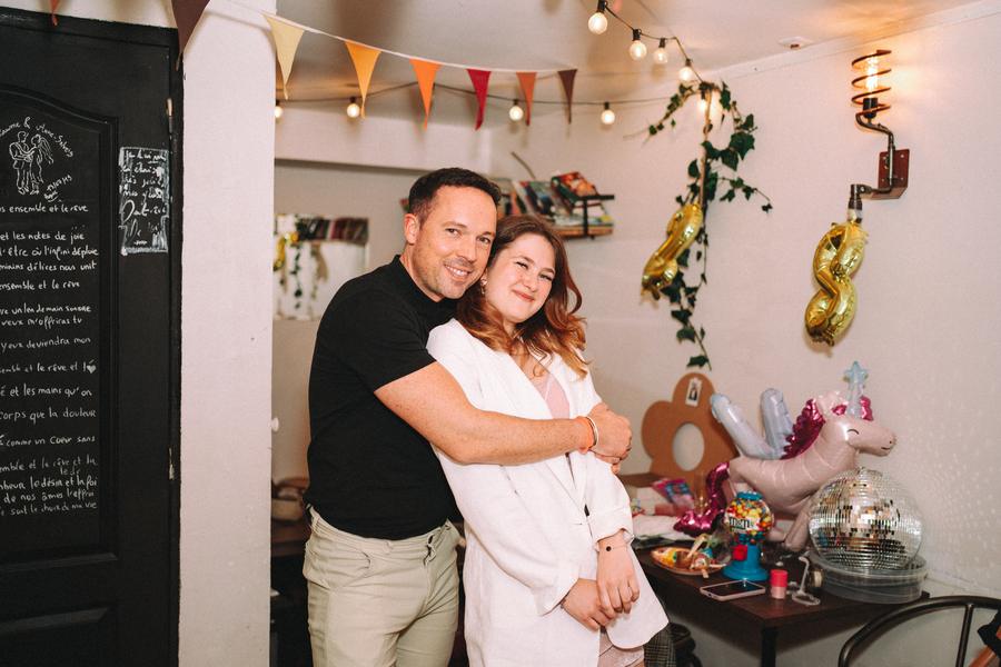 Un couple enlacé devant les ballons d'anniversaire