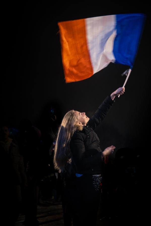 Une silhouette agite un drapeau dans l'obscurité