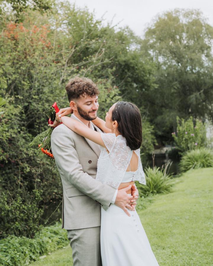 La mariée, les bras autour du cou du marié, se regardent en souriant