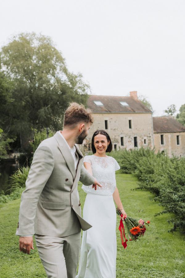 Le marié entraîne la mariée par la main, elle rit