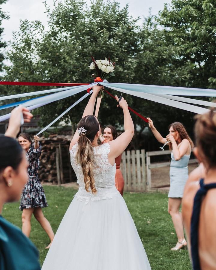 La mariée et ses amies tirent sur des rubans colorés