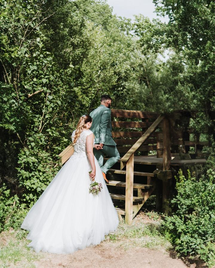 La mariée devant un escalier en bois dans la verdure