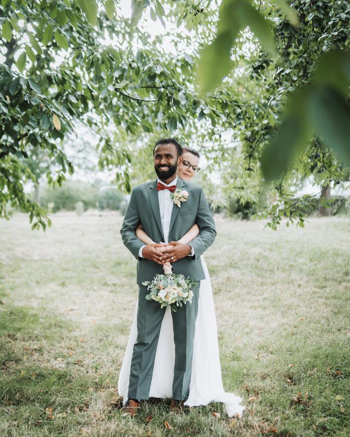 Le marié et la mariée enlacés dans un jardin