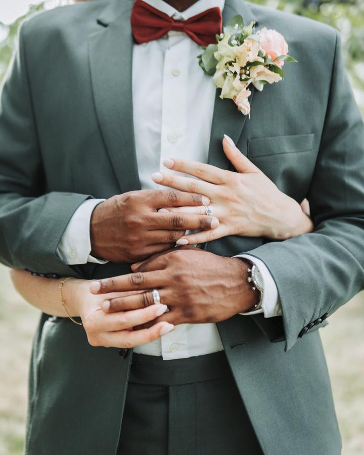 Les mains de la mariée posées sur la veste du marié