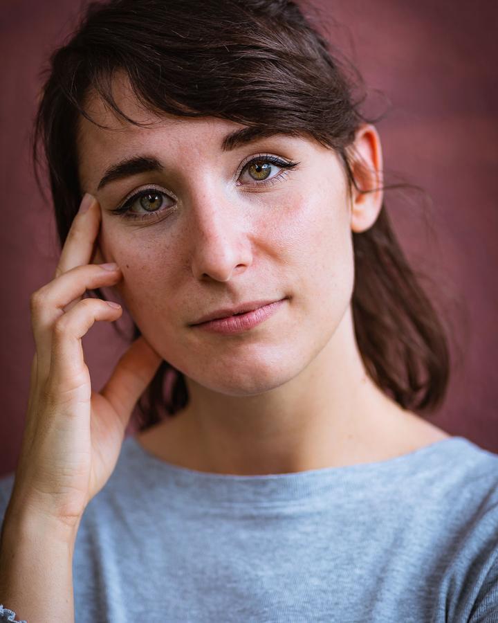 Portrait serré d'une femme, la main sur la tempe